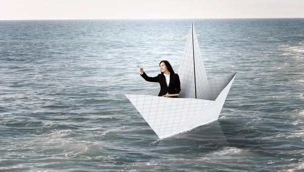 Бизнесмен в лодке из бумаги — стоковое фото