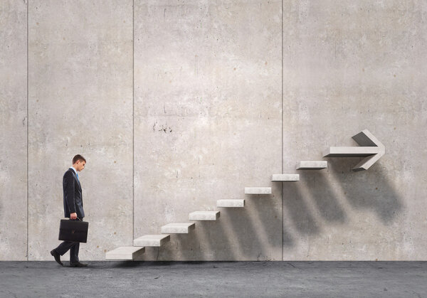 Businessman with suitcase stepping up stone staircase