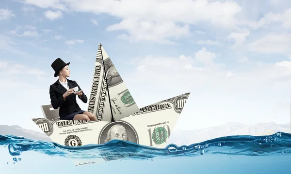 Businesswoman in boat made of dollar banknote — Stock Photo, Image