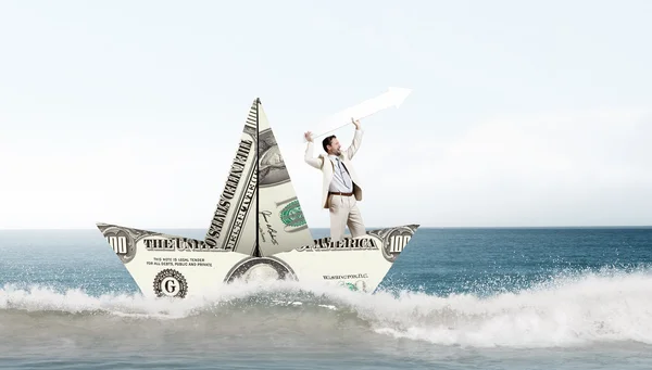 Empresario en barco hecho de billete de dólar —  Fotos de Stock