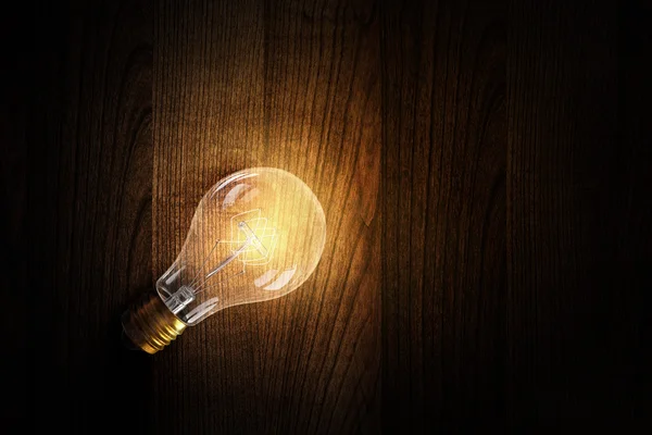 Light bulb op houten oppervlak — Stockfoto