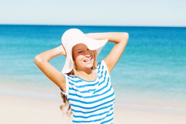 Genç bir kadın sahilde dinleniyor.