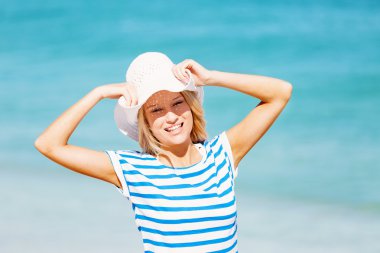 Genç bir kadın sahilde dinleniyor.