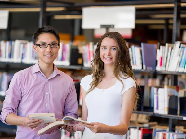 Двоє молодих студентів в бібліотеці — стокове фото