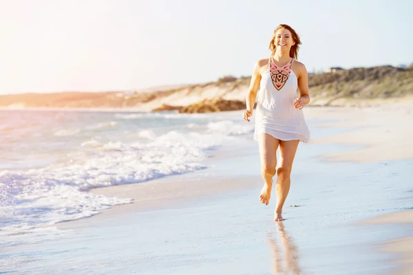 Jonge vrouw wandelen langs het strand — Stockfoto