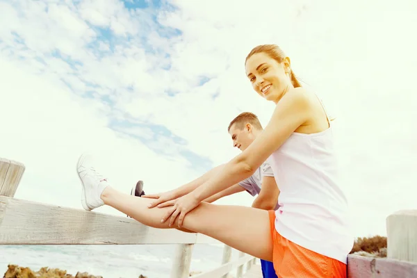 Corredores. Pareja joven haciendo ejercicio en la playa — Foto de Stock