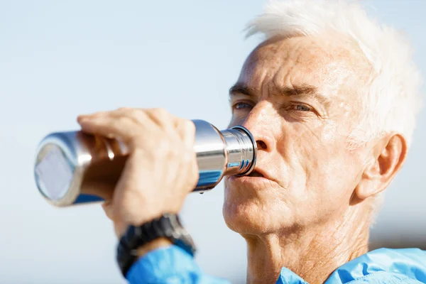 Homme buvant dans une bouteille de sport — Photo