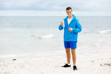 Şişe su ile tutarak kendine güvenen genç adam