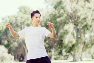 Yakışıklı adam Thai Chi yapıyor.