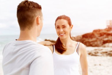 Kaçakçıları. Egzersiz ve stertching sahilde genç Çift