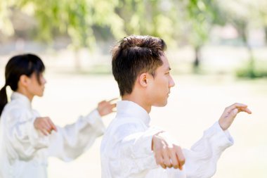 Yakışıklı adam Thai Chi yapıyor.