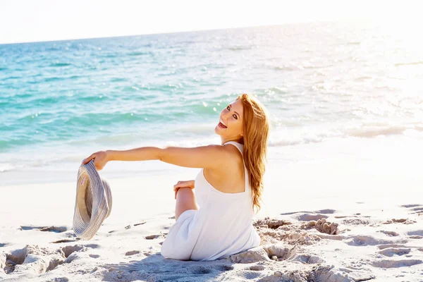 Genç bir kadın sahilde oturuyor. — Stok fotoğraf