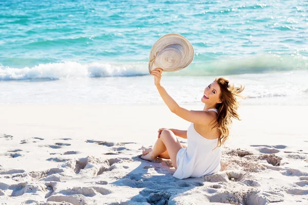 Jovem mulher sentada na praia — Fotografia de Stock