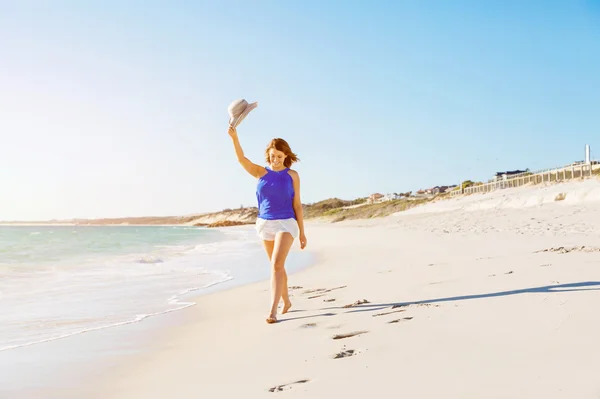 Giovane donna a piedi lungo la spiaggia — Foto Stock