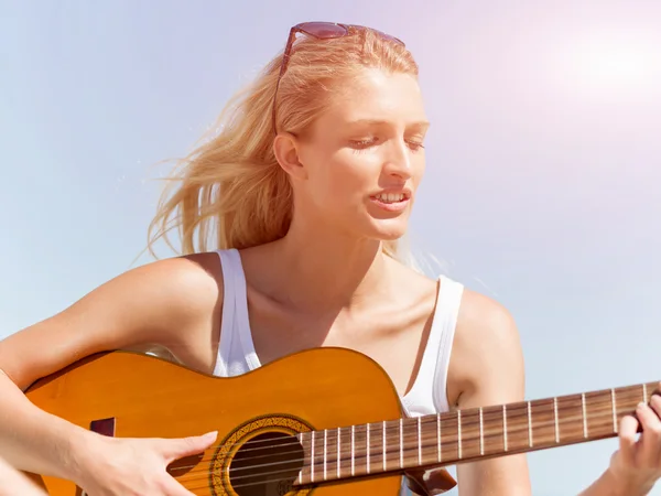 Belle jeune femme jouant de la guitare sur la plage — Photo