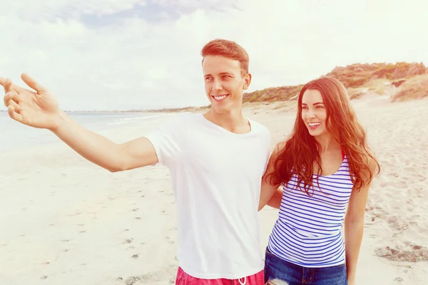 Glückliches junges Paar beim gemeinsamen Spaziergang am Strand — Stockfoto