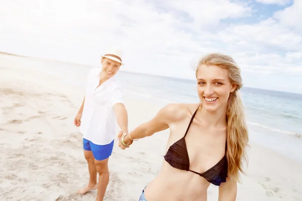 Romantiska unga paret sitter på stranden — Stockfoto