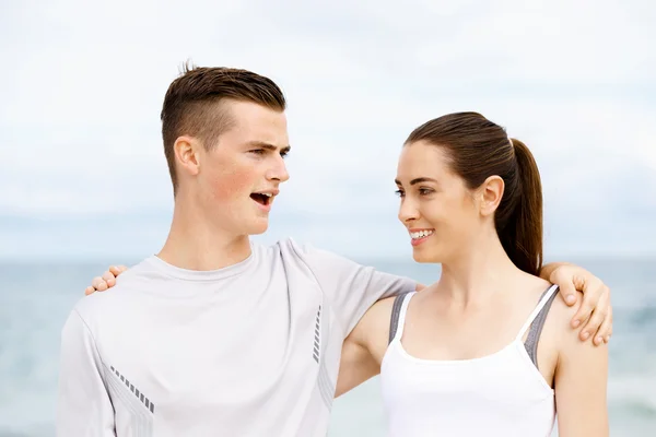 Young couple looking at each other on beach — Stock Photo, Image