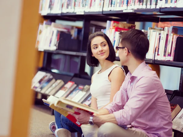 Dva mladí studenti v knihovně — Stock fotografie