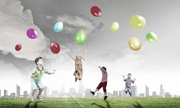 Enfants ludiques attraper des ballons — Photo