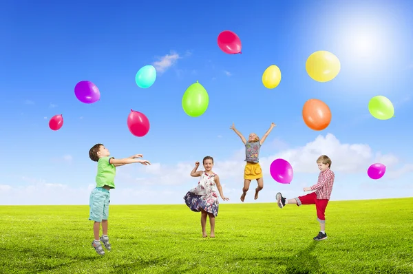 Игривые дети ловят воздушные шары — стоковое фото