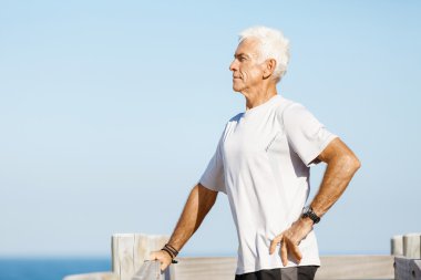 Adam ayakta bir kumsalda bulunan spor giyim