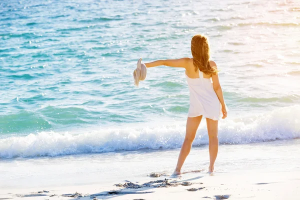 Junge Frau läuft am Strand entlang — Stockfoto