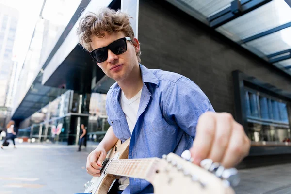 Młody muzyk z gitara w mieście — Zdjęcie stockowe
