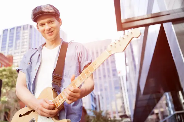 Joven músico con guitarra en la ciudad — Foto de Stock