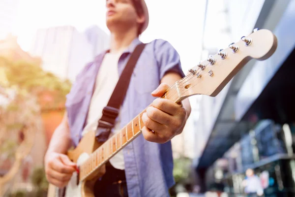 Młody muzyk z gitara w mieście — Zdjęcie stockowe