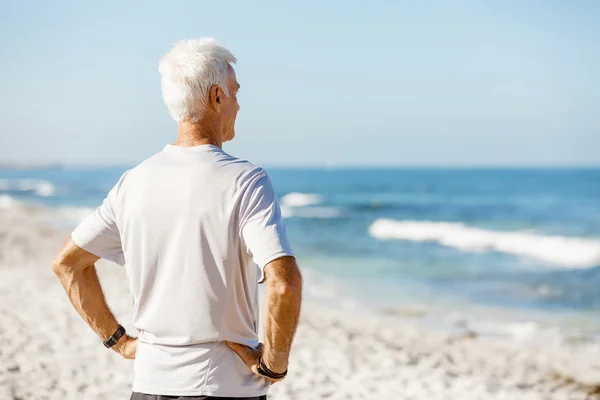 Muž, který stojí na pláži v sportovní oblečení — Stock fotografie