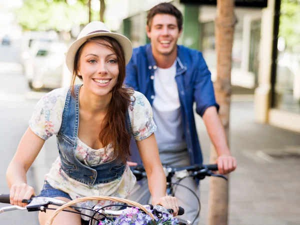 Happy couple in city with bike — Stock Photo, Image