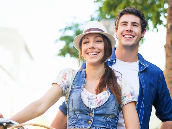 Happy couple in city with bike — Stock Photo, Image