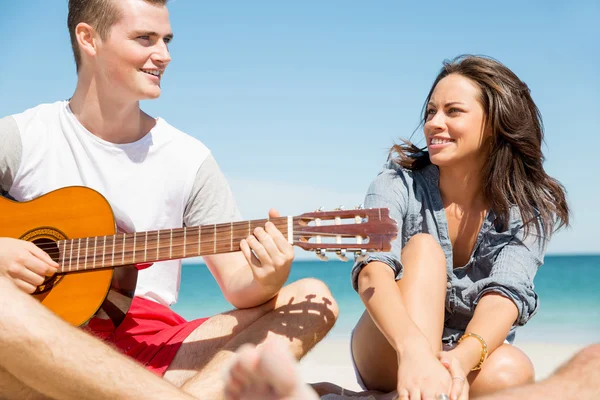 Schöne junge Leute mit Gitarre am Strand — Stockfoto