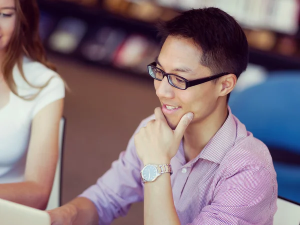 Happy male student working at the library — Stock Photo, Image