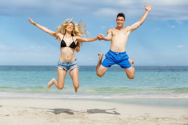 Ευτυχισμένο ζευγάρι άλμα σε παραλία διακοπές — Φωτογραφία Αρχείου