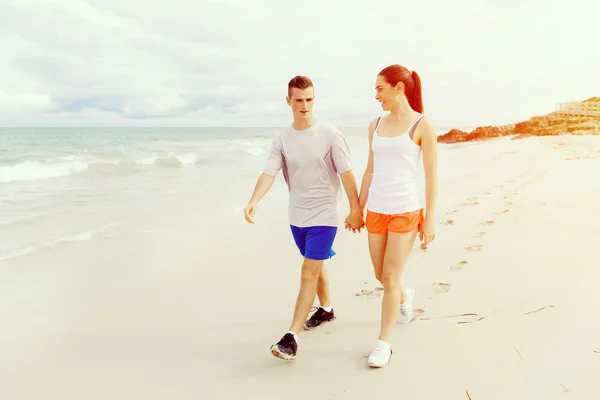 Бегуны. Молодая пара бегает по пляжу — стоковое фото