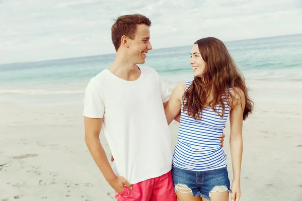 Romantische jonge paar staande op het strand — Stockfoto