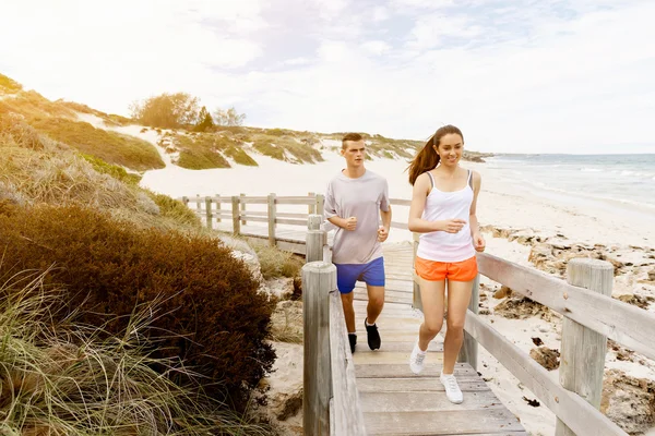 Des coureurs. Jeune couple courant sur la plage — Photo