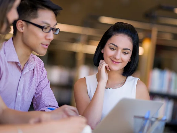 Group of young students at the library — Stock Photo, Image