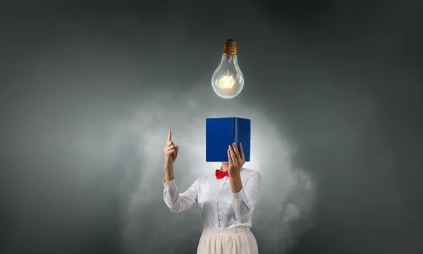 Woman hiding face behind book — Stock Photo, Image