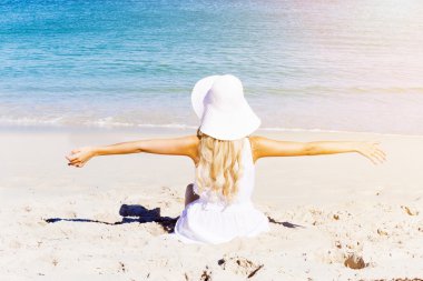 Genç bir kadın sahilde dinleniyor.