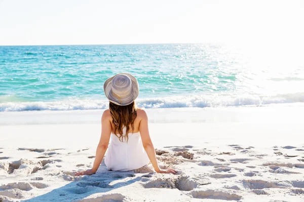 Mujer joven sentada en la playa —  Fotos de Stock
