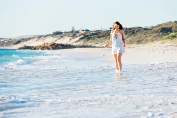 Junge Frau läuft am Strand entlang — Stockfoto