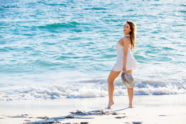 Junge Frau läuft am Strand entlang — Stockfoto