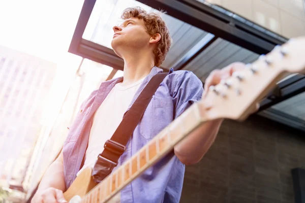 Jovem músico com guitarra na cidade — Fotografia de Stock