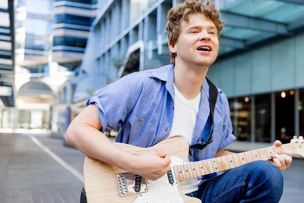 Young musician with guitar in city — Stock Photo, Image