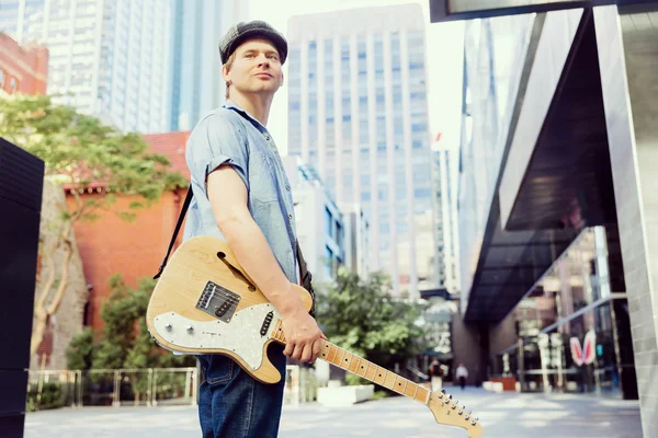 Young musician with guitar in city — Stock Photo, Image