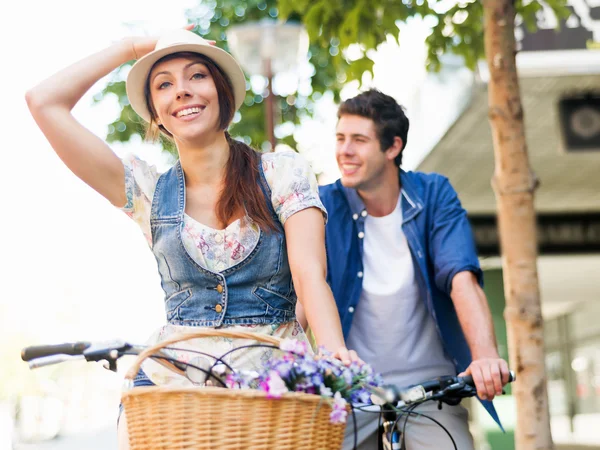 Happy couple in city with bike — Stock Photo, Image