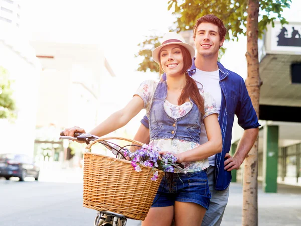 Счастливая пара в городе на велосипеде — стоковое фото